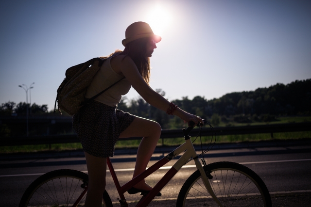 リュックを背負って自転車に乗る女性