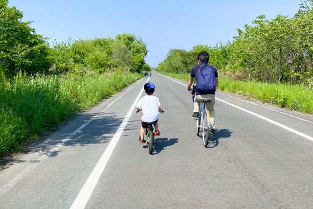 サイクリングロードをサイクリングする親子